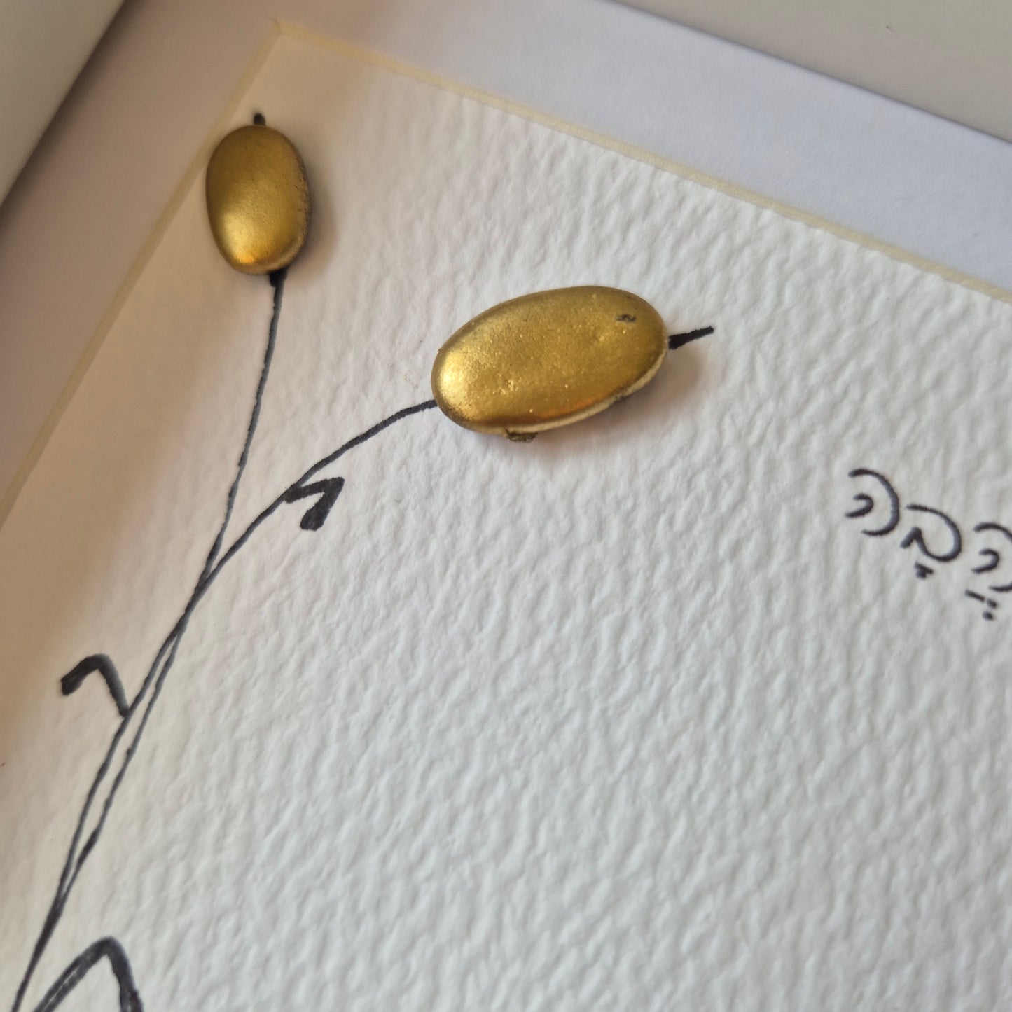 כאן גרה אהבה – יצירת קיר באבני קרמיקה כחולות וקני סוף מוזהבים